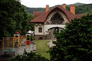 Elegant house with a playground in a scenic mountain setting.