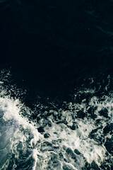A captivating view of dark ocean waters meeting frothy white waves, creating a beautiful contrast in color and texture. Perfect for ocean-themed projects.