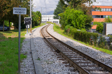 Obraz premium Winding railway track with scenic landscape at Swiss village of Agno on a sunny late summer day. Photo taken September 12th, 2025, Agno, Switzerland.