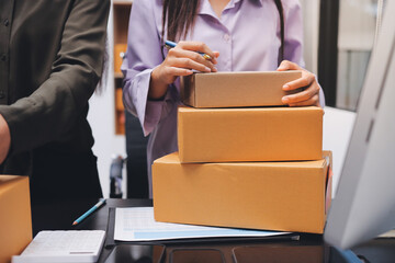Portrait of Starting small businesses SME owners, two Asian woman check online orders Selling products working with boxs freelance work at home office, sme business online small medium enterprise