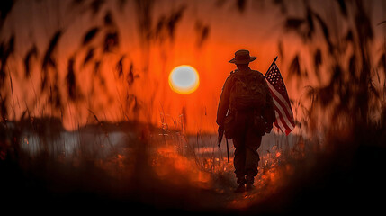 Silhouette of a soldier with USA flag against the sunset. Memorial Day