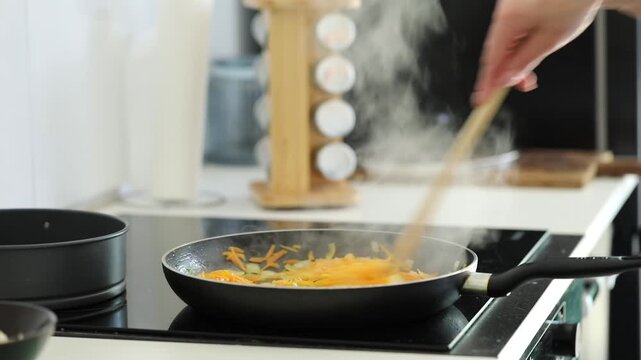 Woman frying veggies for stew at home