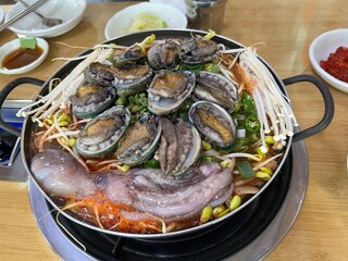 동그란 냄비에 담긴 맛있는 콩나물과 전복, 낙지,새우 해물탕 