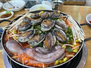 동그란 냄비에 담긴 맛있는 콩나물과 전복, 낙지,새우 해물탕 
