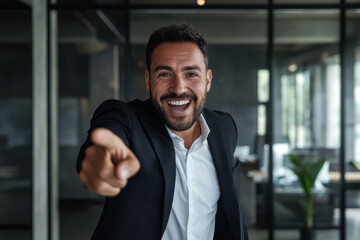 Fototapeta premium happy surprised businessman pointing at you in modern office background