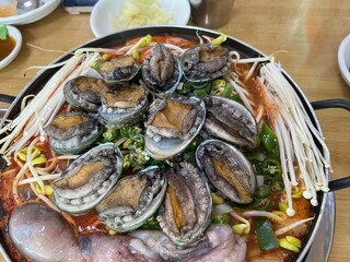 동그란 냄비에 담긴 맛있는 콩나물과 전복, 낙지,새우 해물탕 