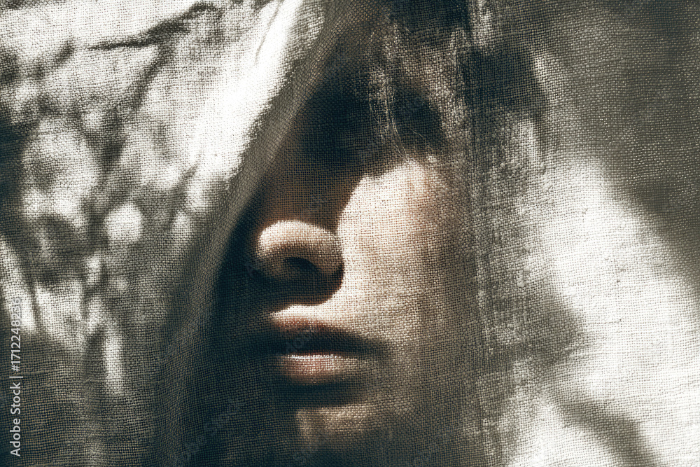 Poster serene face partially visible under textured fabric soft natural light mysterious mood close up shad