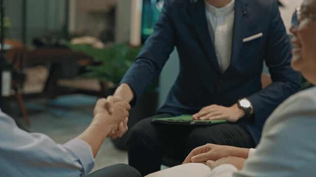 Male psychologist talking to a senior couple during therapy session in modern office, providing emotional support and professional counseling for mental health, communication and relationship care - Powered by Adobe