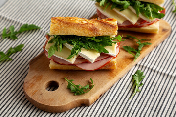 Homemade French Ham and Brie Baguette with Arugula Greens, side view.
