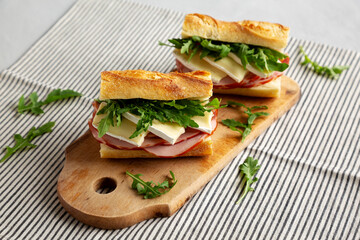 Homemade French Ham and Brie Baguette with Arugula Greens, side view.