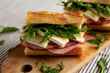 Homemade French Ham and Brie Baguette with Arugula Greens, side view. Close-up.