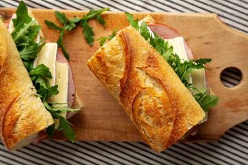 Homemade French Ham and Brie Baguette with Arugula Greens, top view. Close-up.