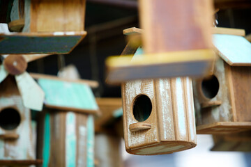 Wooden Birdhouses in Various Shapes and Colors Hanging Outdoors
