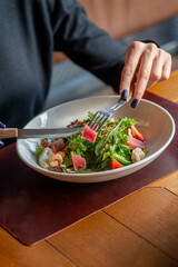 Unrecognizable woman eating tuna salad in a restaurant