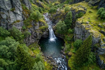 Scenic waterfall cascading into a serene pool surrounded by lush greenery in a remote valley