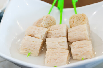 tofu skewers soaked in water, showing cubes of bean curd prepared for cooking, vegetarian food and healthy meal concept.