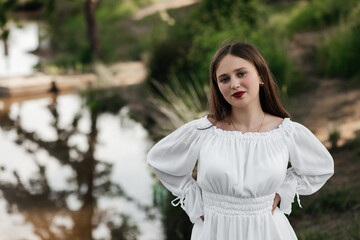 A woman in a white dress by the lake