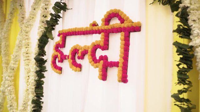 Traditional "Haldi" sign in Hindi, made of marigold flowers, for an Indian wedding pre-wedding ceremony backdrop decoration.