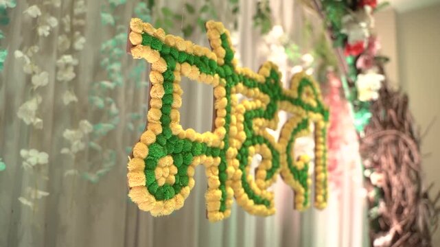 Traditional "Haldi" sign in Hindi, made of marigold flowers, for an Indian wedding pre-wedding ceremony backdrop decoration.