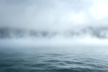 Obraz premium Atmospheric seascape with dense fog hovering over calm ocean waters creating mysterious moody scenery in cool blue tones, dramatic minimalist nature background.