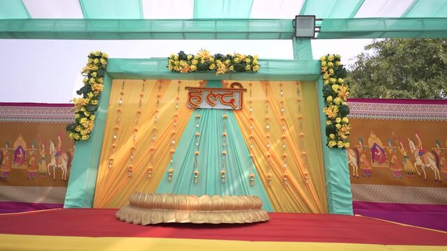 Beautifully decorated stage for traditional Indian Haldi ceremony, pre-wedding celebration setup with flowers and drapes