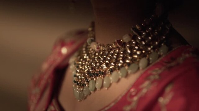 Elegant reveal: Close-up of a stunning traditional Indian bridal necklace, rich with gems, on a woman's neckline.