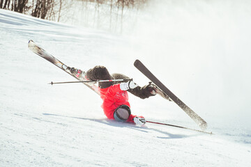 Skier fall down hit head painfully on hard groomed piste with snow swirls on ski resort slope....