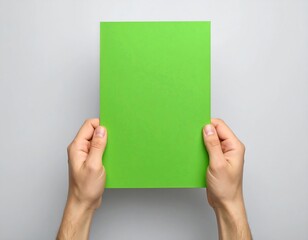 Hands holding a blank lime green sheet of paper