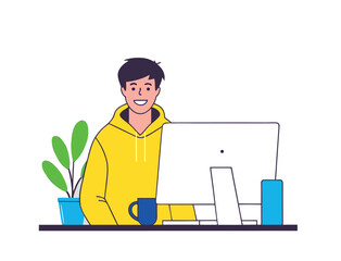 A smiling man in a yellow hoodie sits at a desk, happily working on a desktop computer