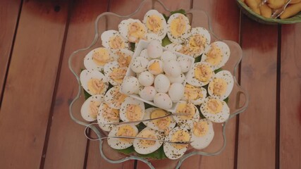 Boiled eggs sliced and whole arranged on platter with herbs for buffet catering event
