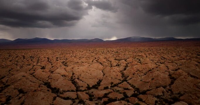 Otherworldly dry landscape of Siloli desert with dramatic storm clouds, aerial