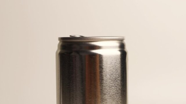 Silver aluminum soda beverage can standing isolated on a bright white background showing metal texture and top pull tab
