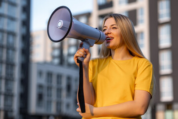 Woman using a megaphone for announcement outdoors in an urban area