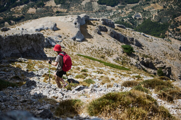 Obraz premium Hiker Exploring a Rocky Mountain Trail on a Sunny Afternoon