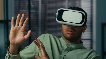 Scared worried african american man wearing virtual reality glasses playing scary 3d game in...