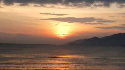 Morning seashore landscape with dramatic sunrise sky  ,peaceful sea and mountains on the horizon...