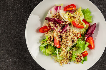Quinoa salad tomato, green leaf salad vegetables dish natural product tasty snack fresh gourmet food background on the table rustic top view copy space keto and paleo diet vegan and vegan food