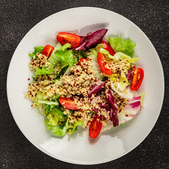 Quinoa salad tomato, green leaf salad vegetables dish natural product tasty snack fresh gourmet food background on the table rustic top view copy space keto and paleo diet vegan and vegan food