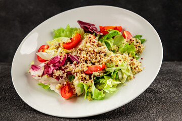 Quinoa salad tomato, green leaf salad vegetables dish natural product tasty snack fresh gourmet food background on the table rustic top view copy space keto and paleo diet vegan and vegan food