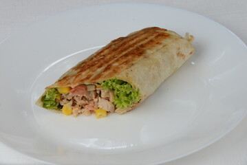 fajito with chicken and vegetables in a white plate 