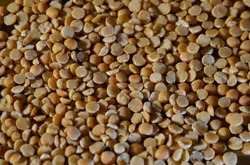 A seamless texture background made of dry yellow peas scattered across the surface. Natural organic food backdrop, healthy eating and cooking ingredient.