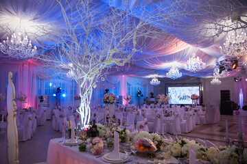 Elegant wedding reception with decorated tables and beautiful lighting in a banquet hall