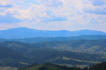 Fototapeta premium A majestic mountain range that melts into the blue haze on the horizon creates an impressive landscape that conveys the boundlessness of space and tranquility.