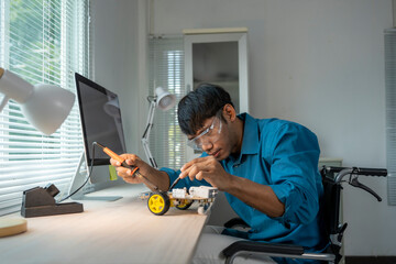 Asian engineer in wheelchair repairing robot in modern office