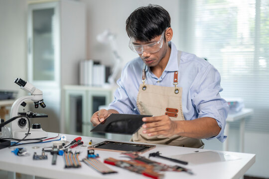 Technician repairing broken tablet in modern workshop