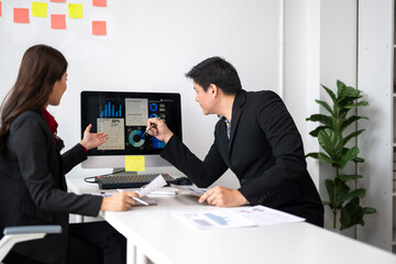 Business people analyzing financial charts and graphs on computer screen