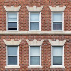 Naklejka premium Classic red brick facade with orderly windows revealing timeless urban residential architecture in Cambridge, Massachusetts, USA 