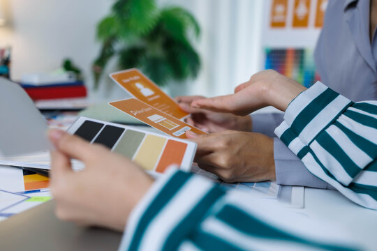 A group of people are working on a project together, with a variety of colorful materials spread out on a table. Scene is collaborative and creative, as the group works together to come up with ideas
