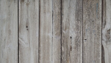 Fototapeta premium A simple, clear background of a wall made of weathered wood, with visible knots, lines, and a light-colored, rustic finish.