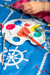 Child painting an egg box with a brush